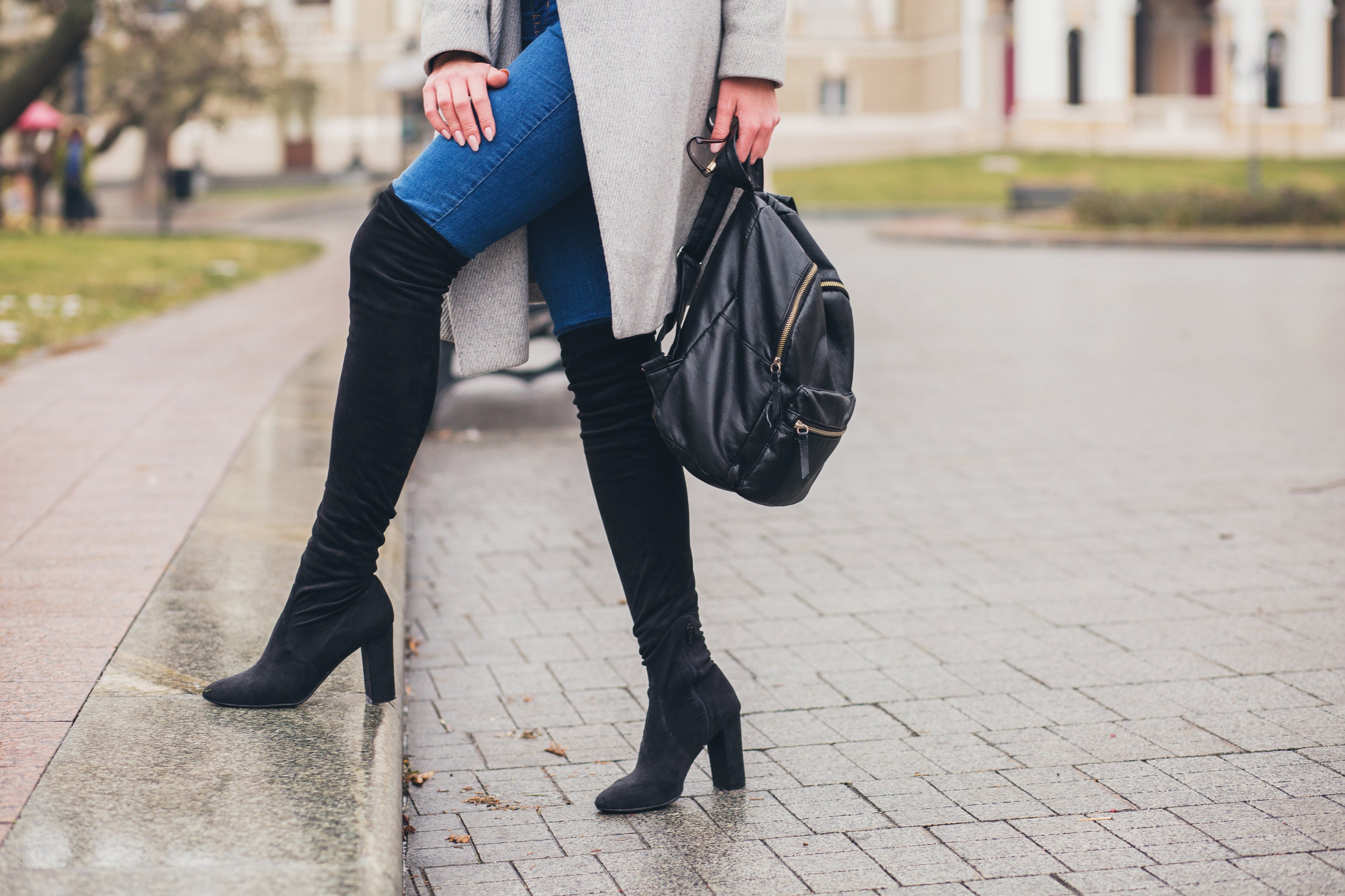 Shooting photo d'une femme portant des bottes noir élégant dans la rue
